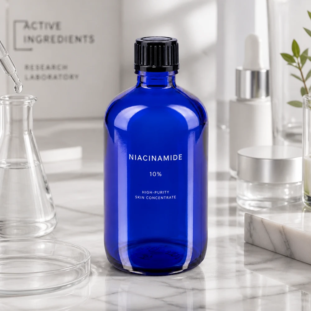 Botella de farmacia azul 100ml tapón cuentagotas 1mm negro estándar Frasco de farmacia azul cobalto de 100 ml con etiqueta de niacinamida sobre una superficie de mármol en un entorno de laboratorio