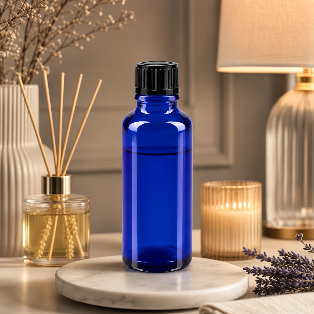 Frasco de farmacia azul de 30 ml con tapón cuentagotas negro, junto a lavanda y un difusor de aroma para el hogar