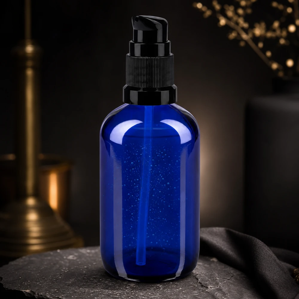 Elegante frasco con dosificador de 100 ml en azul cobalto con dosificador negro sobre fondo de pizarra oscura