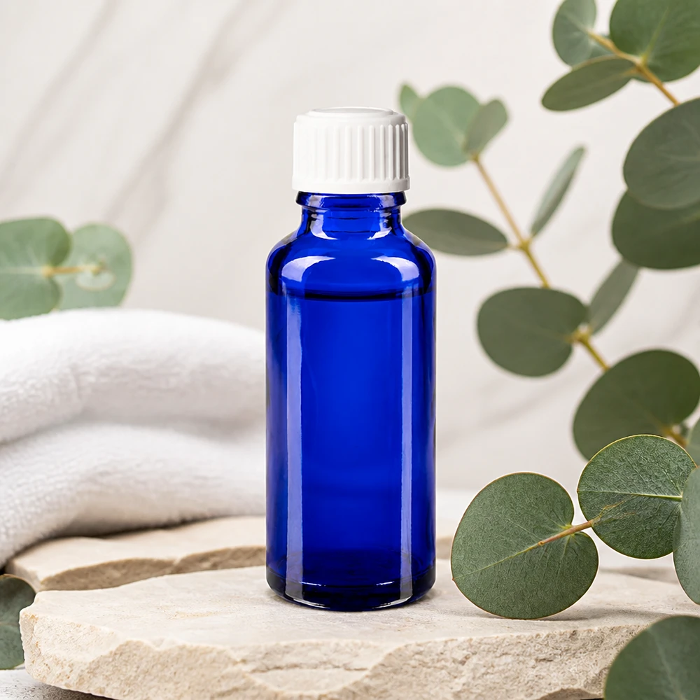 Frasco de farmacia azul cobalto de 30 ml con tapón cuentagotas blanco sobre piedra natural con aroma a eucalipto