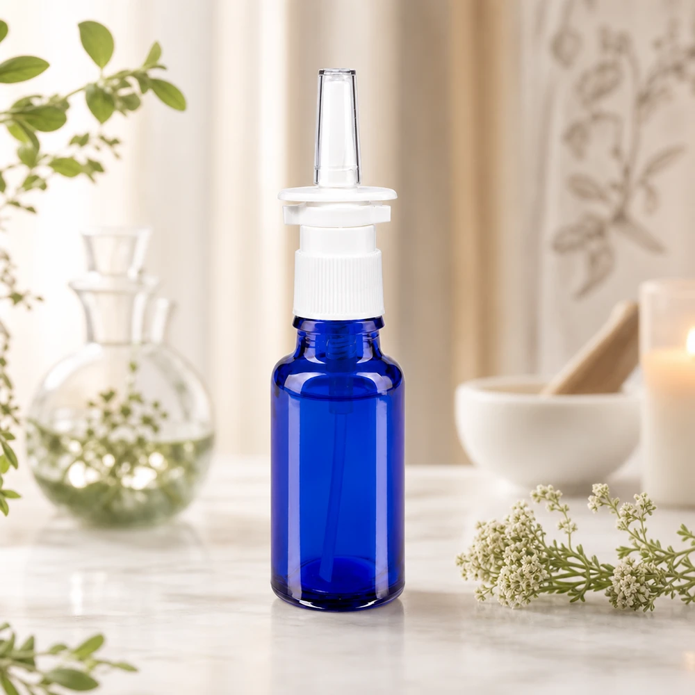 Frasco farmacéutico azul de 20 ml con dosificador de spray nasal blanco y boquilla aplicadora transparente, con un paisaje natural de fondo