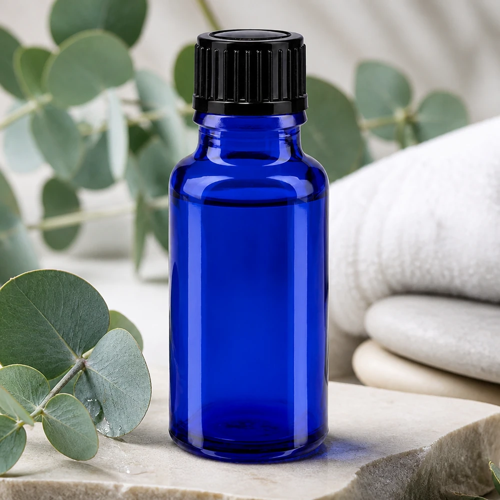 Pequeño frasco de farmacia azul de 20 ml con tapón negro sobre piedra natural con aroma a eucalipto