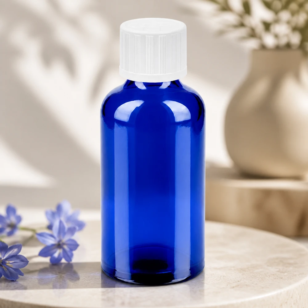 Frasco de cristal compacto de 50 ml en azul brillante con tapón blanco para una dosificación precisa