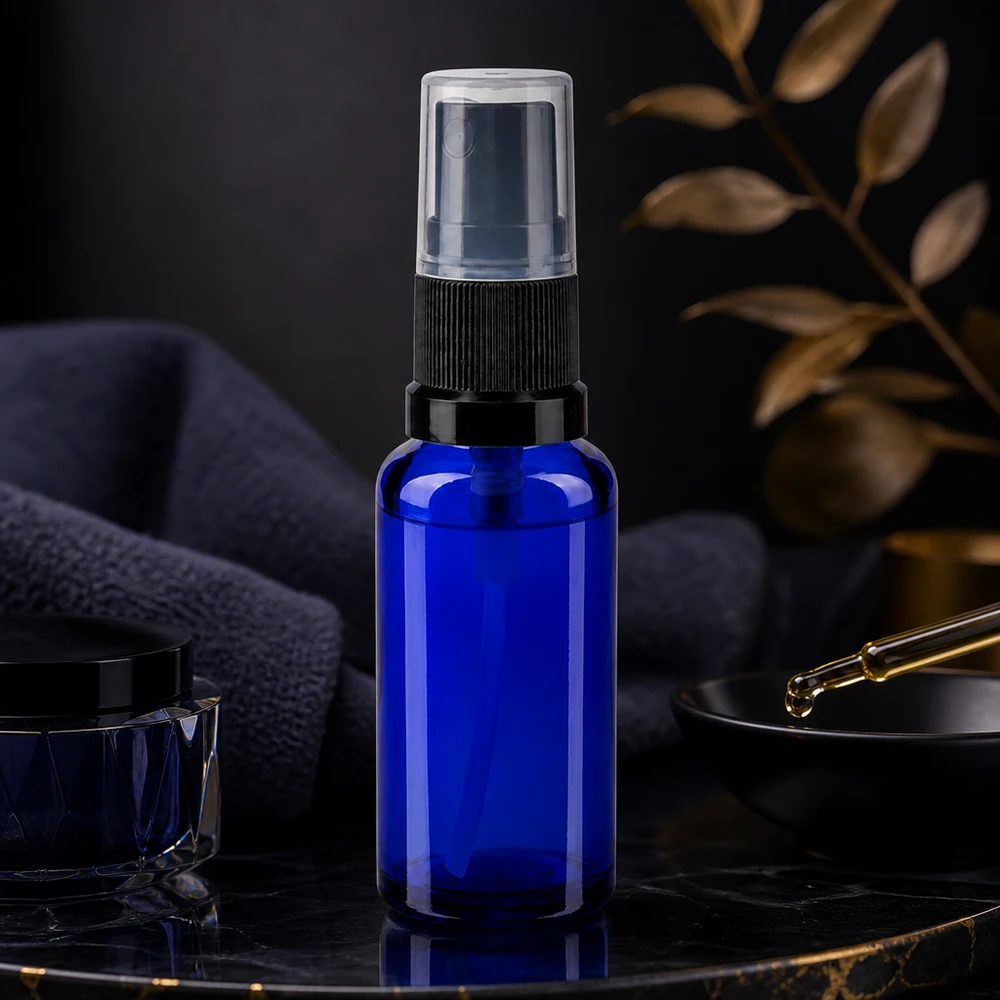 Elegante frasco de farmacia con pulverizador de 30 ml en azul cobalto con pulverizador negro sobre un fondo de mármol oscuro