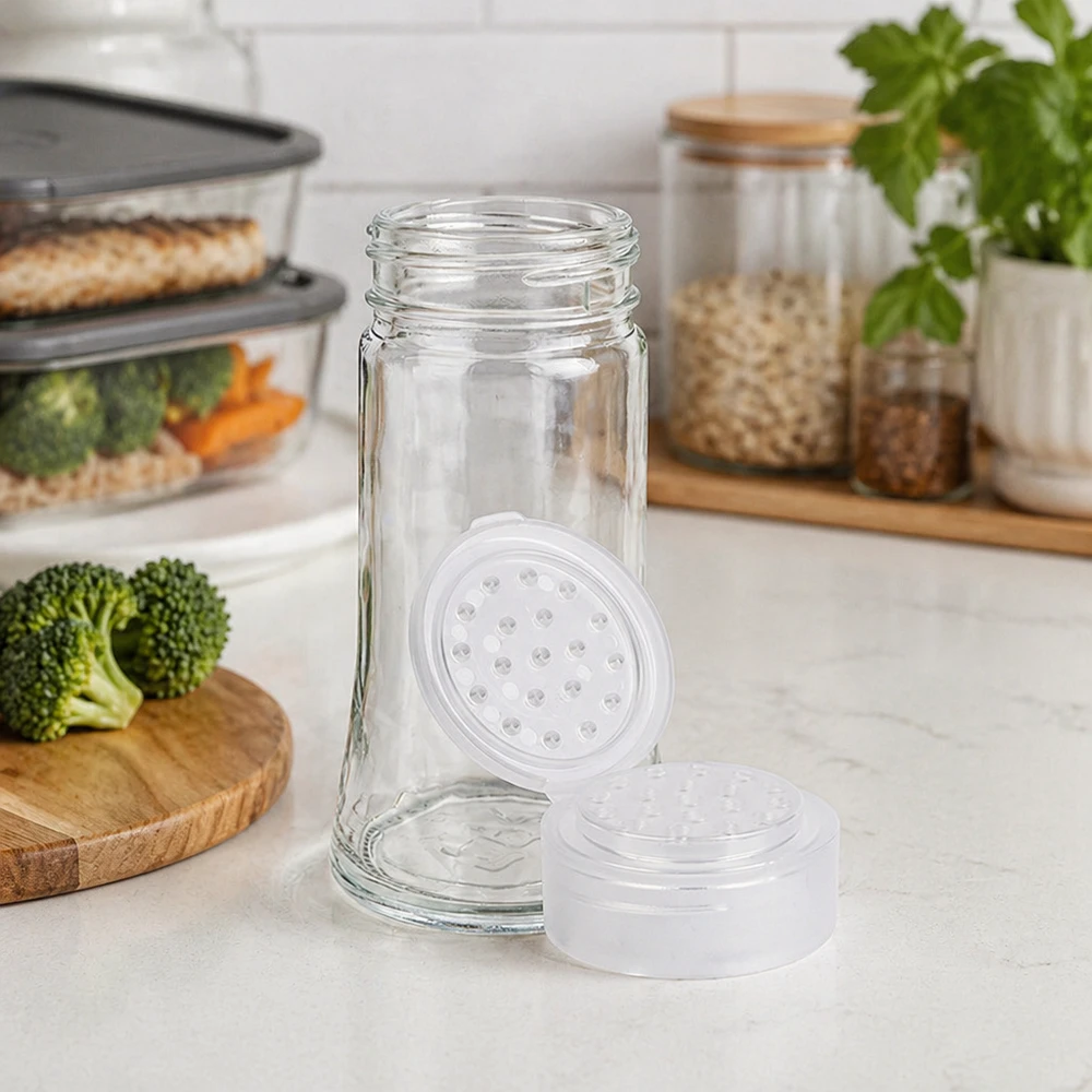 Frasco transparente para especias de 95 ml con dosificador perforado blanco en una cocina moderna con verduras frescas