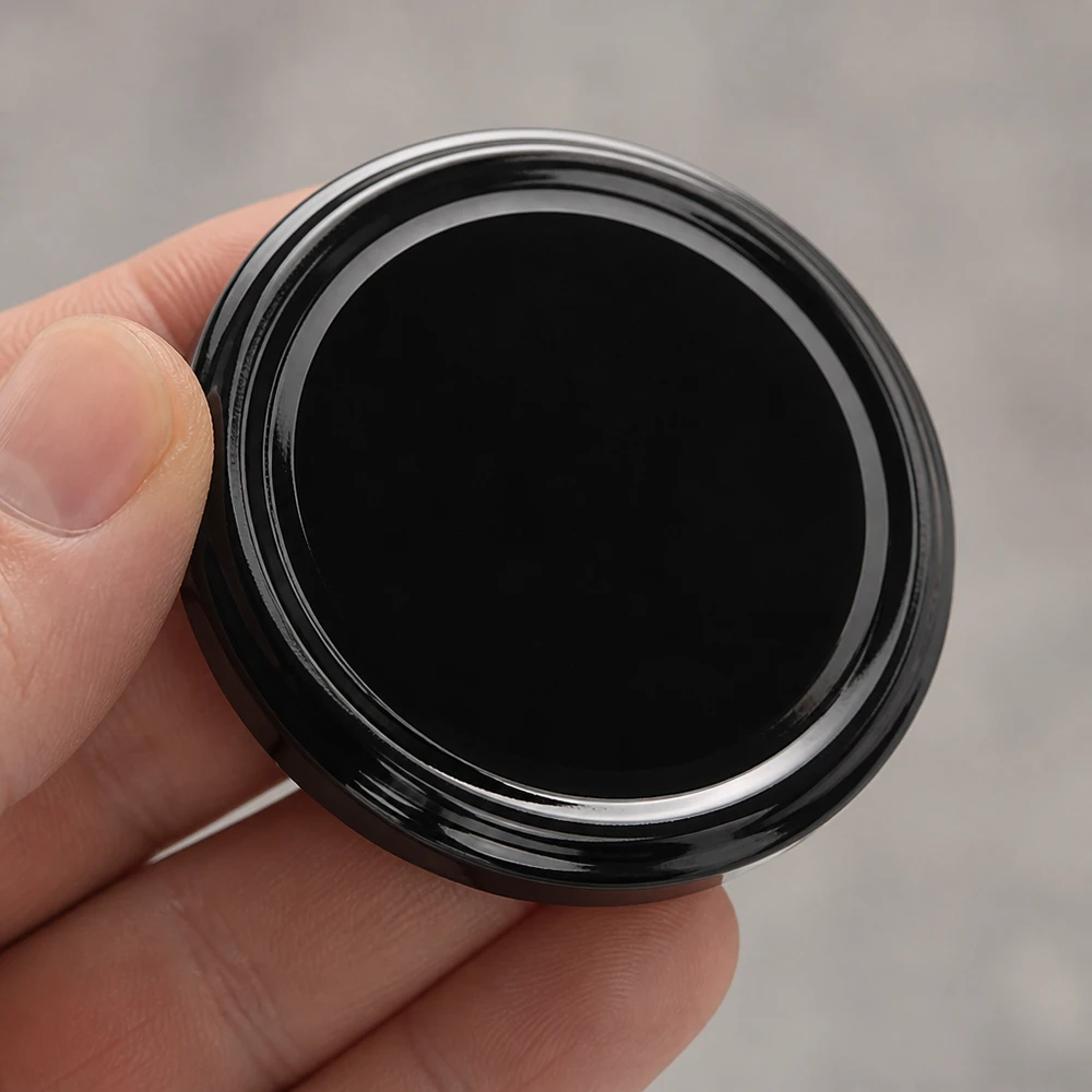 Primer plano de una tapa metálica BasicSeal negra de 70 mm, tipo TO70 UNiTWIST, con superficie brillante