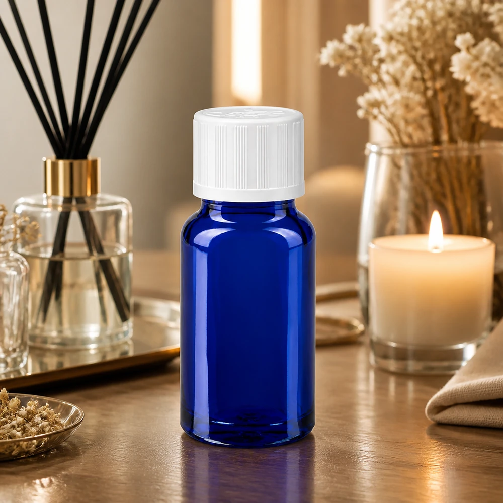 Botella de farmacia azul 10ml tapón de rosca blanco estándar a prueba de niños Pequeña botella de cristal azul de 10 ml con tapón de rosca blanco sobre una mesa de madera, junto a un ambientador y una vela