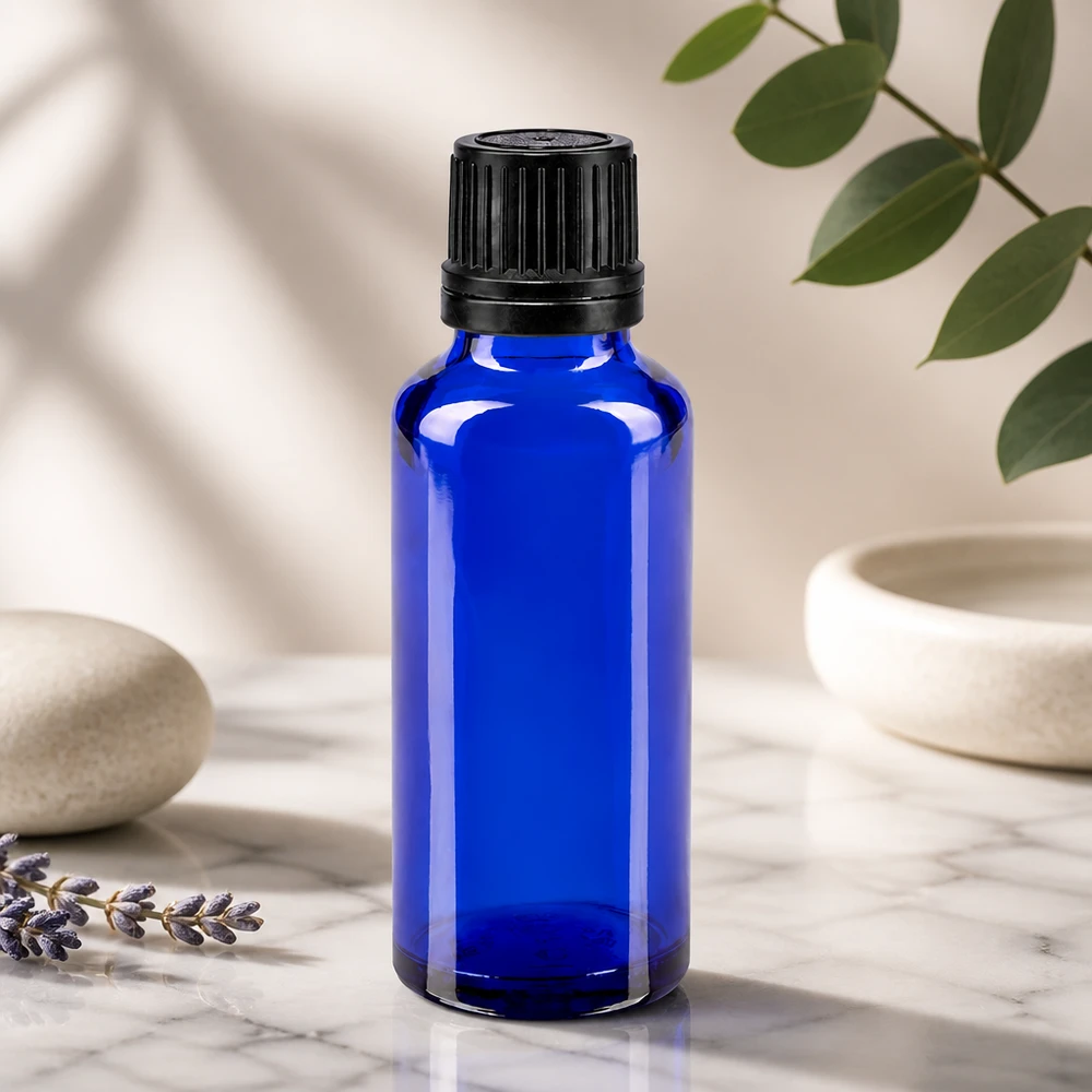 Frasco de cristal de farmacia azul cobalto de 30 ml con tapón de seguridad negro estriado sobre fondo de mármol