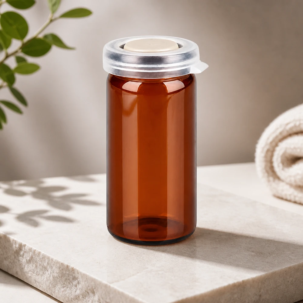 Frasco de farmacia vacío de 10 ml, de color ámbar, con tapón a presión transparente sobre fondo de mármol