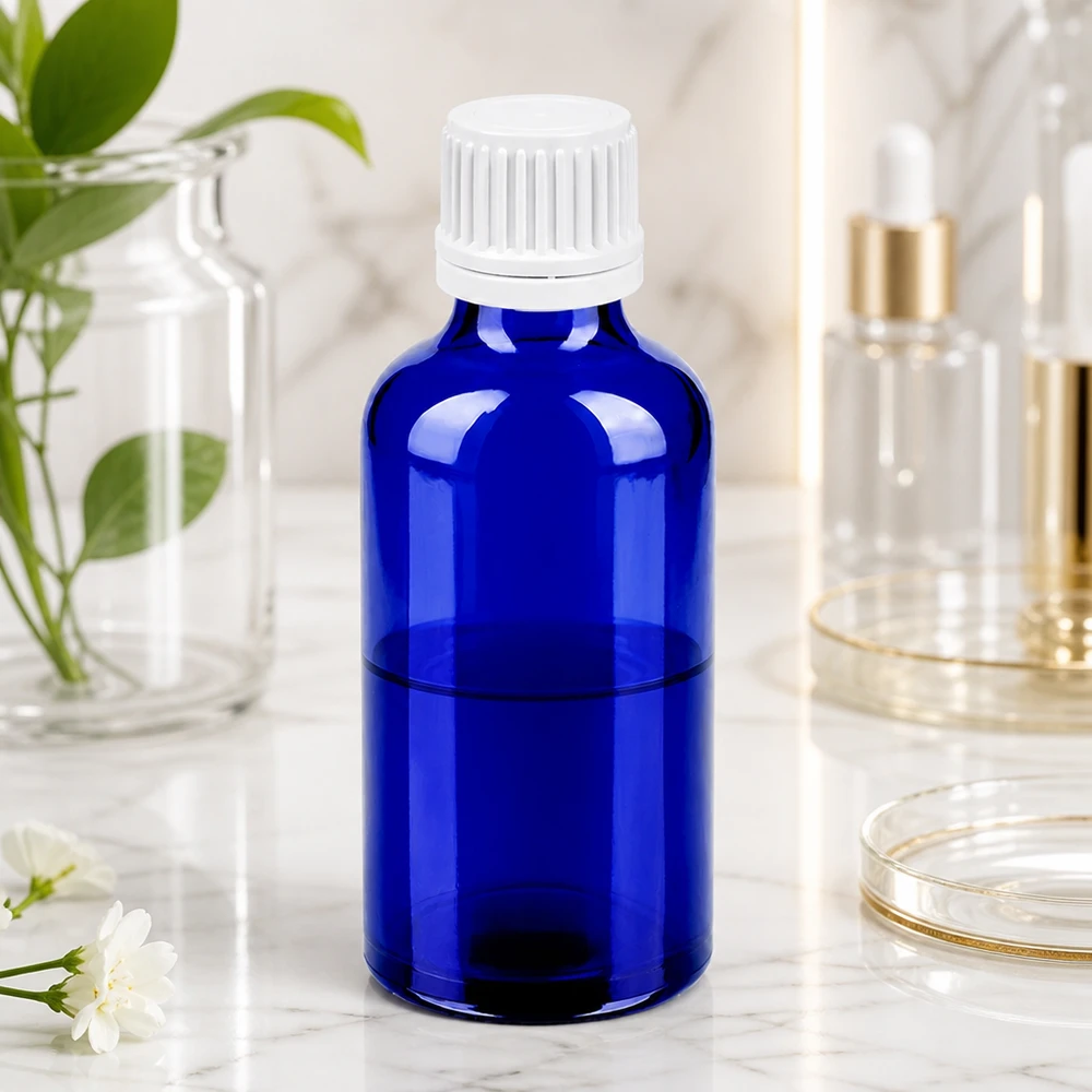 Frasco redondo de vidrio de 50 ml en azul brillante con práctico tapón cuentagotas blanco