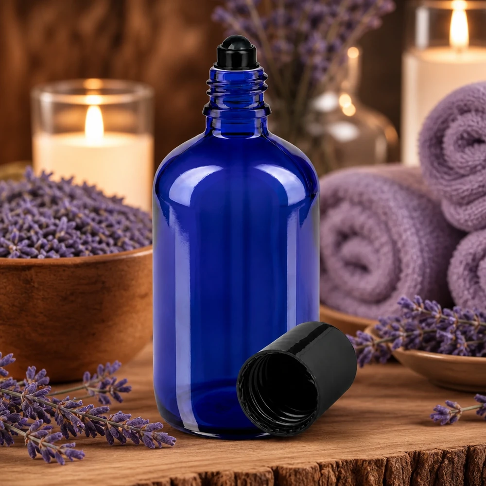 Botella de farmacia azul 100ml roll-on cap negro Frasco de cristal azul de 100 ml con tapón de bola, rodeado de flores de lavanda y velas
