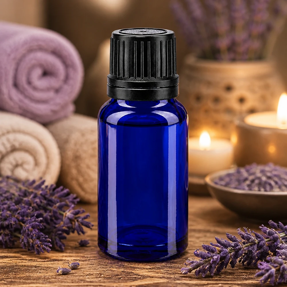 Pequeño frasco de cristal azul de 10 ml con su tapón original negro, rodeado de flores de lavanda y velas
