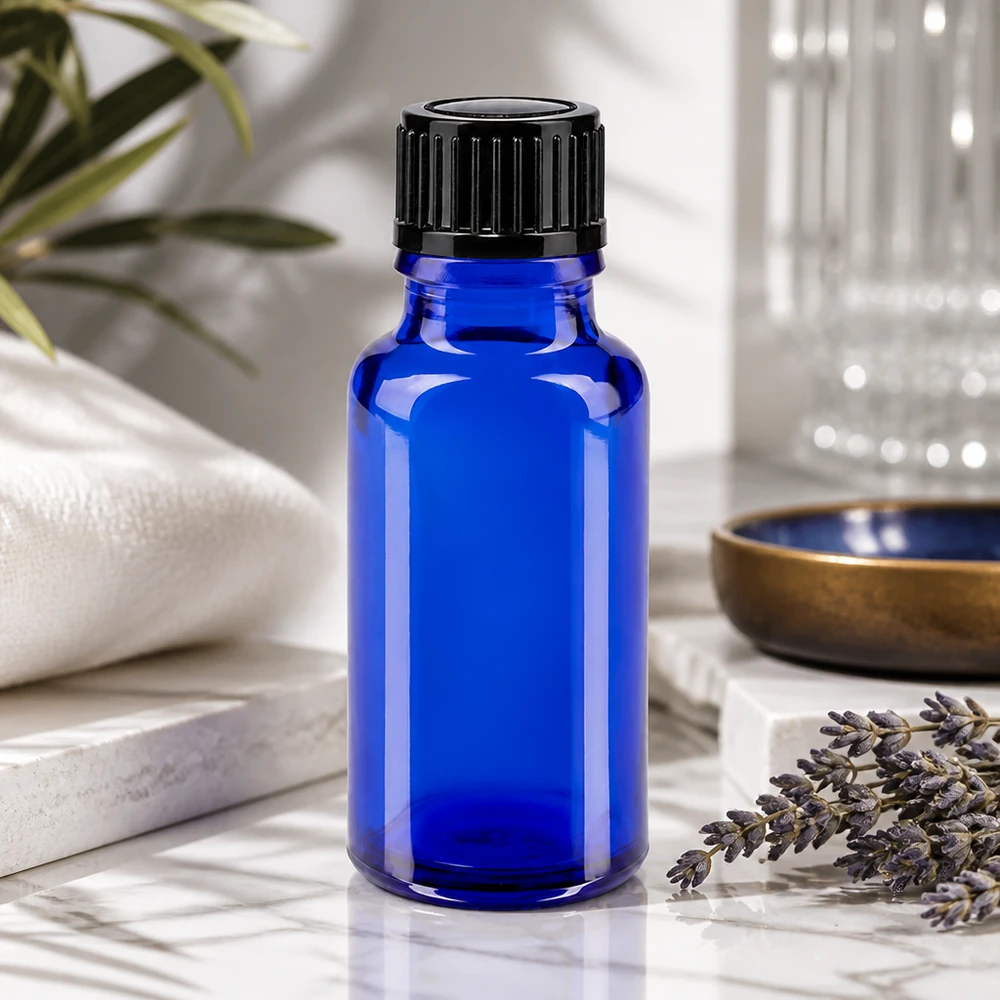 Botella de farmacia azul 20ml tapón rosca negro estándar Frasco de farmacia azul de 20 ml con tapón de rosca negro junto a ramitas de lavanda sobre mármol