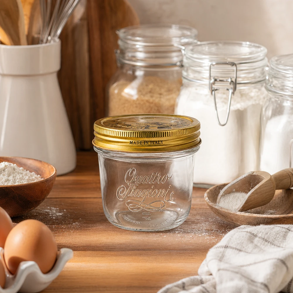 Vasos "Quattro Stagioni" de 200 ml con tapa Vasos Quattro Stagioni de 200 ml con tapa dorada sobre tabla de madera junto a harina, huevos y utensilios de cocina Made in Italy