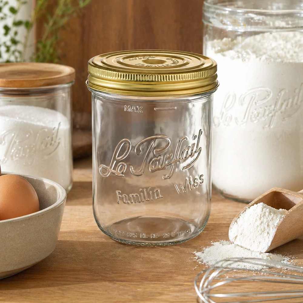 Tarro Familia Wiss de 1020 ml con tapa dorada sobre mesa de madera junto a ingredientes de repostería y otros tarros de conserva
