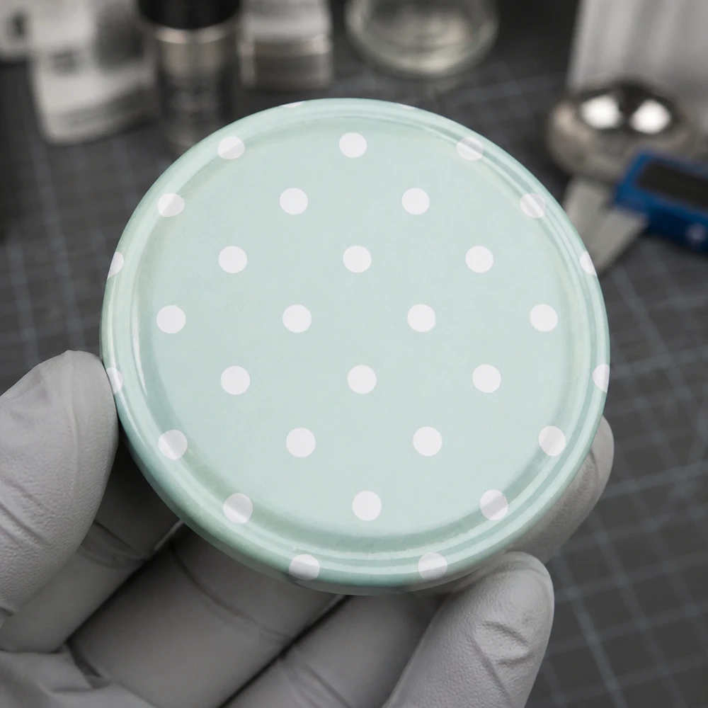 Tapa de rosca BasicSeal de color verde menta de 63 mm con puntos blancos. Vista desde arriba sobre la mesa de la cocina