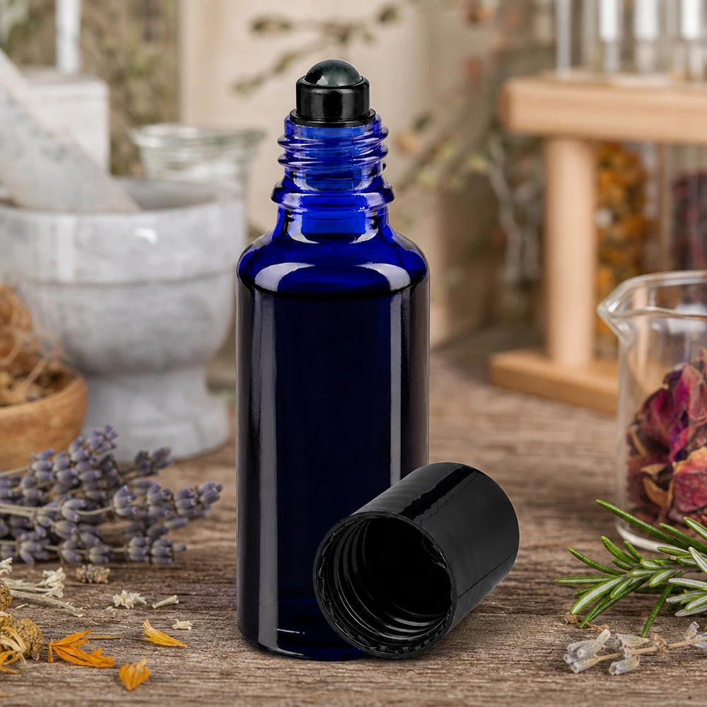 Frasco ApoGlas azul cobalto de 30 ml con aplicador de bola negro entre hierbas secas