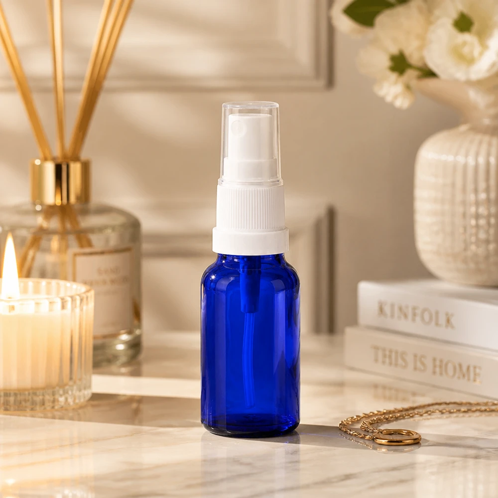 Botella pulverizadora compacta de 10 ml en azul cobalto con accesorio pulverizador blanco para uso móvil