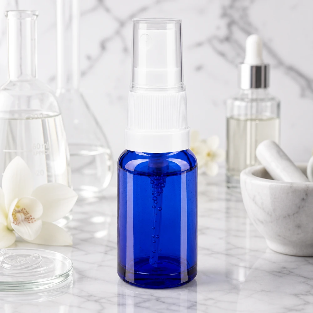 Frasco pulverizador de 10 ml de cristal azul de farmacia con pulverizador blanco sobre fondo de mármol, de estilo de laboratorio