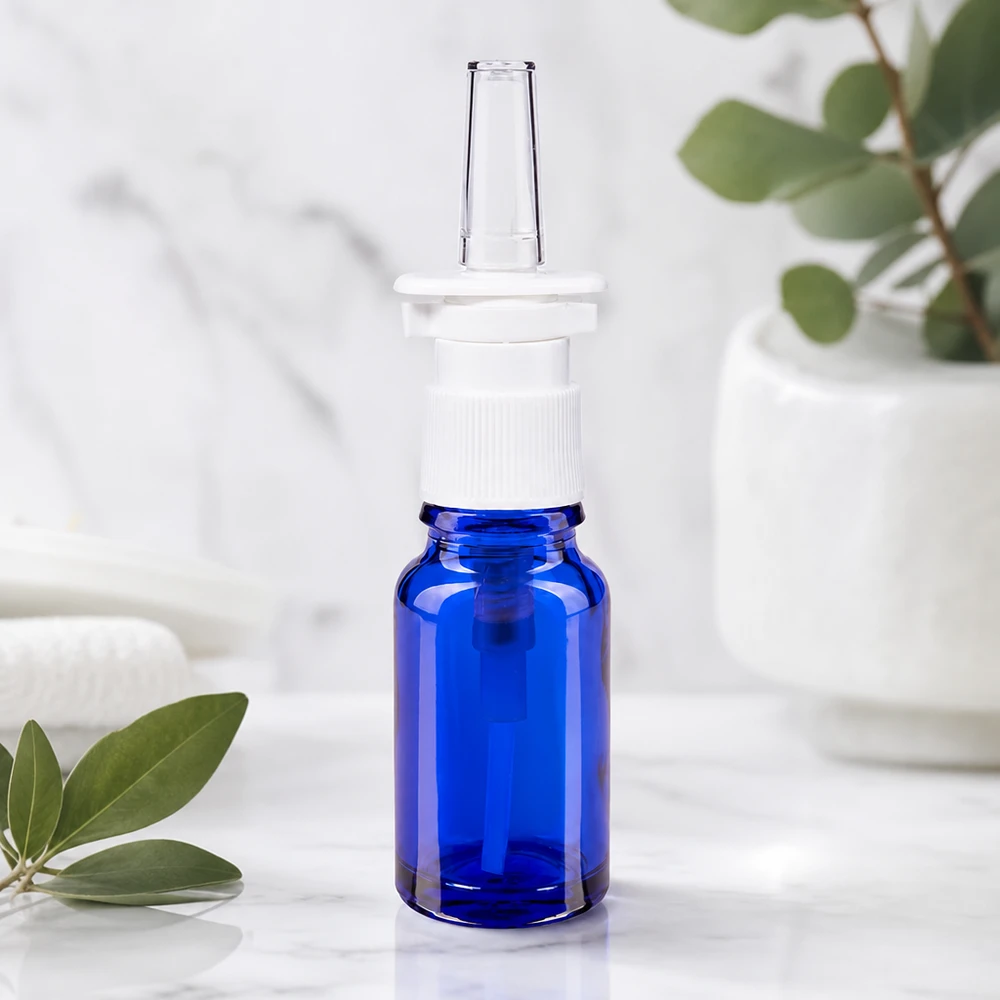 Frasco de cristal azul cobalto de 10 ml con dosificador ergonómico para spray nasal de color blanco