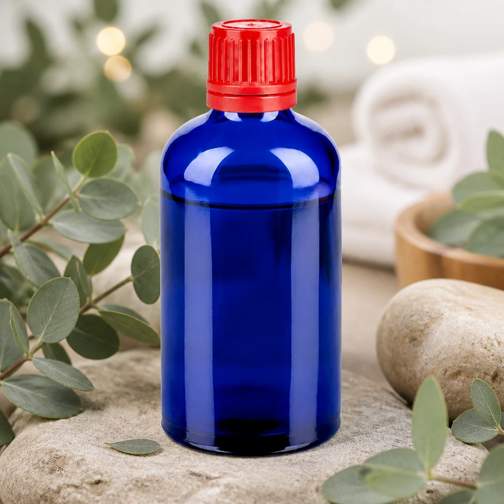 Botella de vidrio de alta calidad de 100 ml en azul cobalto con práctico tapón de rosca de 11 mm SV rojo