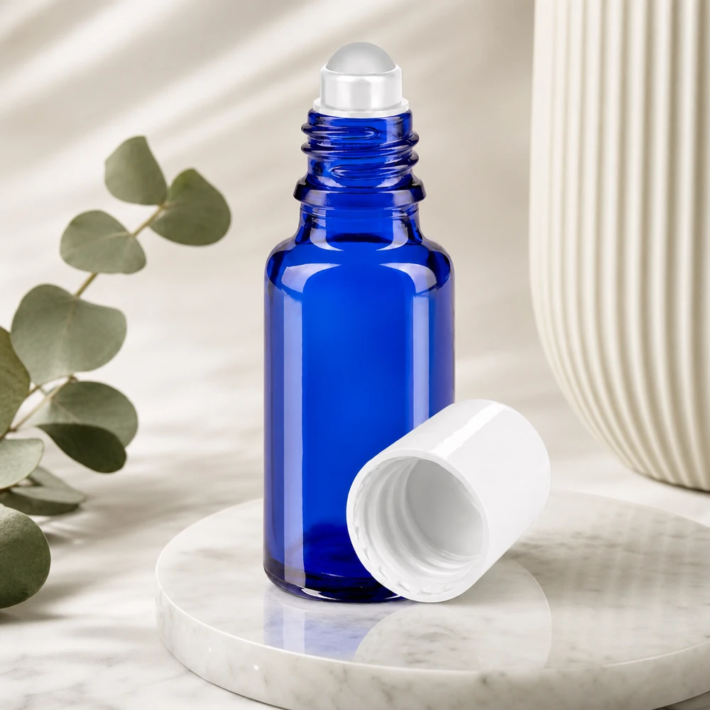 Frasco azul de 20 ml con aplicador de bola, de cristal de farmacia, con la tapa blanca retirada, sobre fondo de mármol