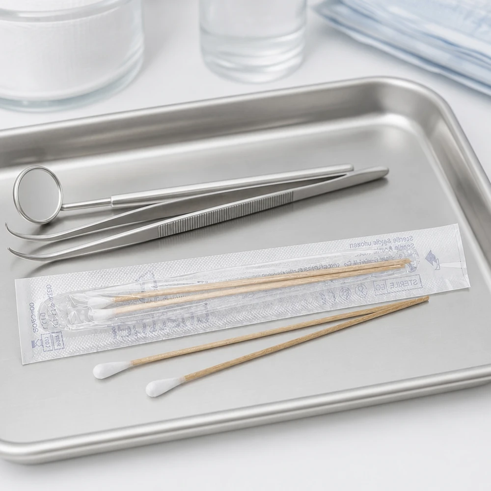 Bastoncillos de algodón estériles en una bandeja médica, junto a instrumentos odontológicos y unas pinzas