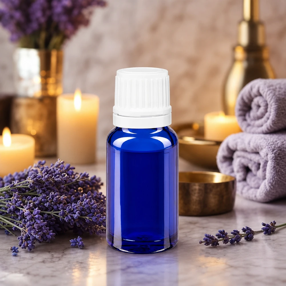 Frasco de cristal azul de 10 ml con gotero, rodeado de flores de lavanda y velas