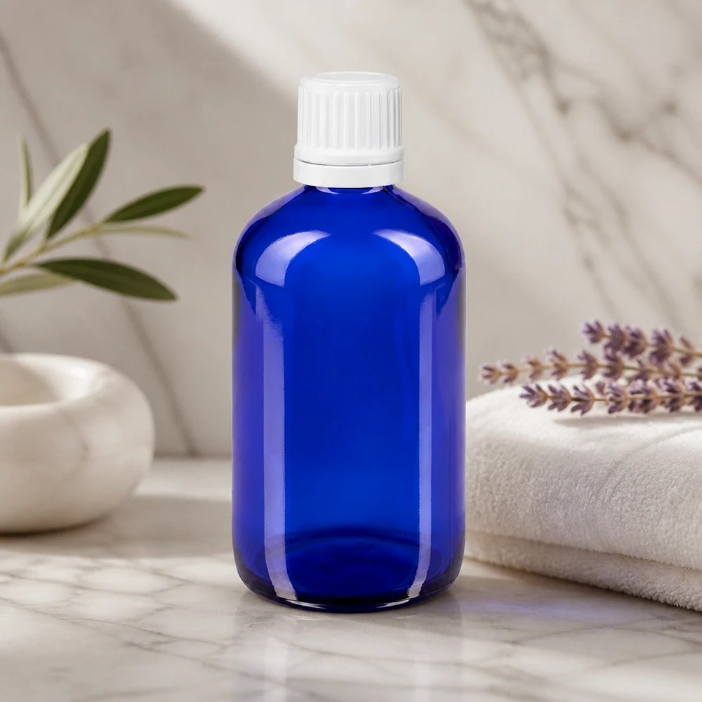 Botella de farmacia azul 100ml tapón cuentagotas 1.2mm blanco inviolable Frasco cuentagotas azul de 100 ml de cristal de farmacia con tapón OV blanco sobre fondo de mármol