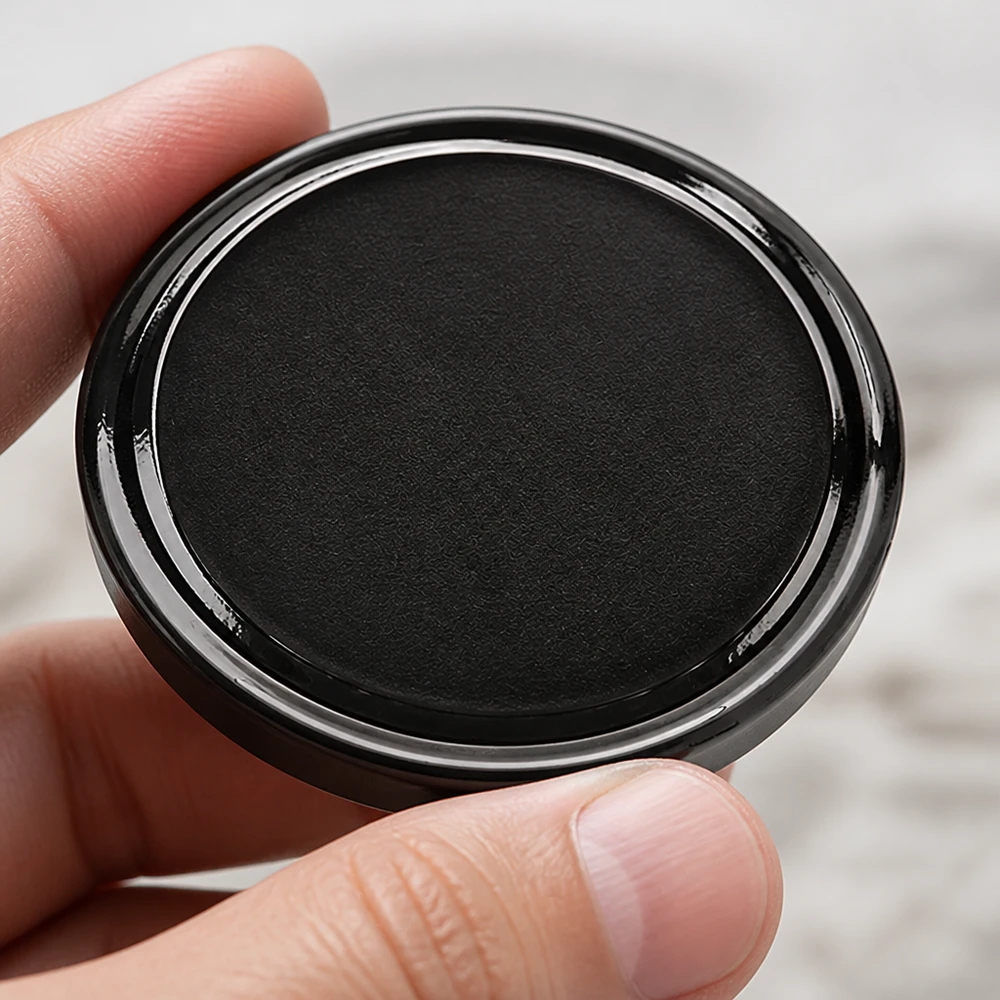 Primer plano de una tapa negra TO58 BasicSeal de 58 mm con UNiTWIST y borde metálico brillante; vista desde arriba