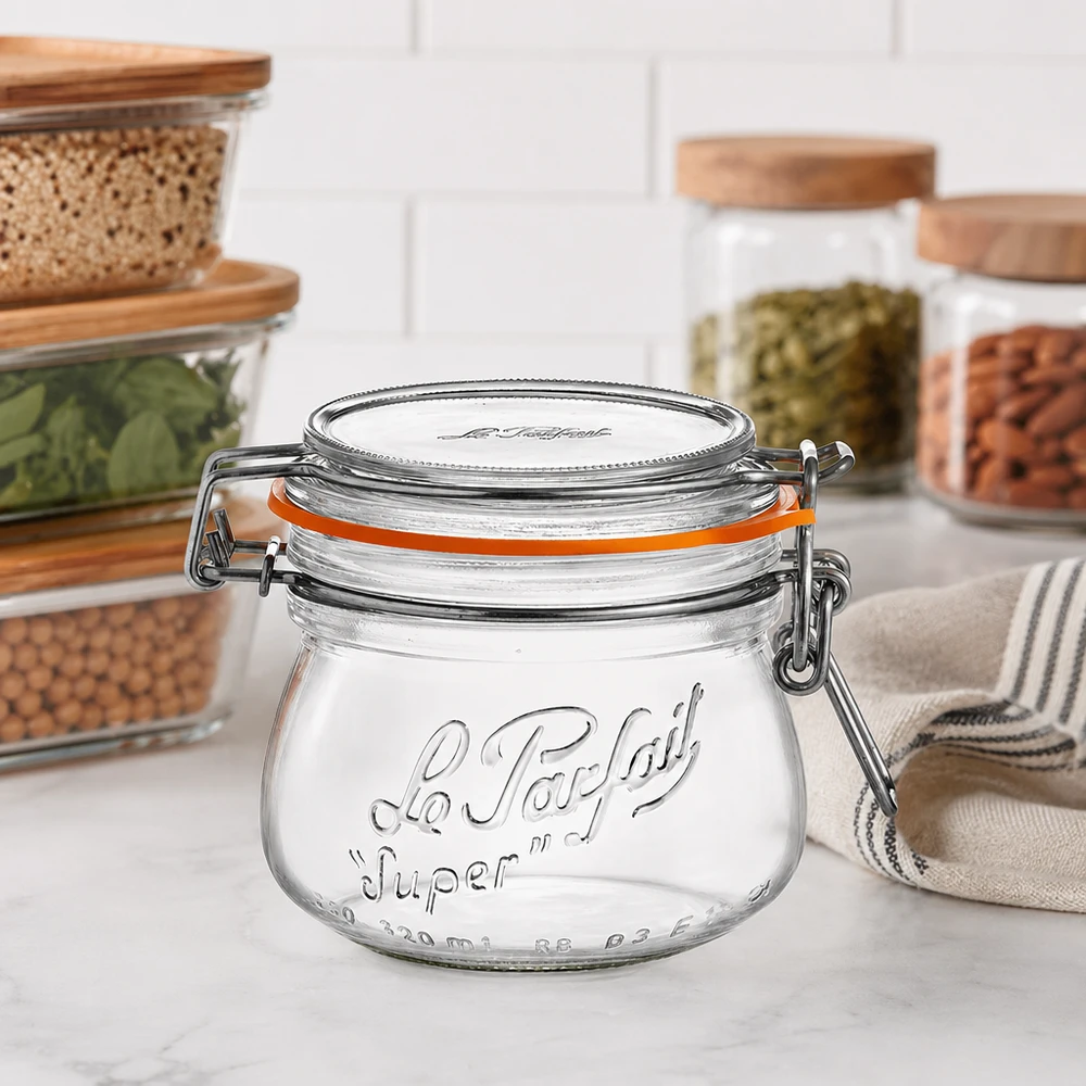 Tarro de almacenamiento Le Parfait Super de 250 ml con tapa abatible y anillo de goma en la encimera de la cocina junto a otros tarros de almacenamiento