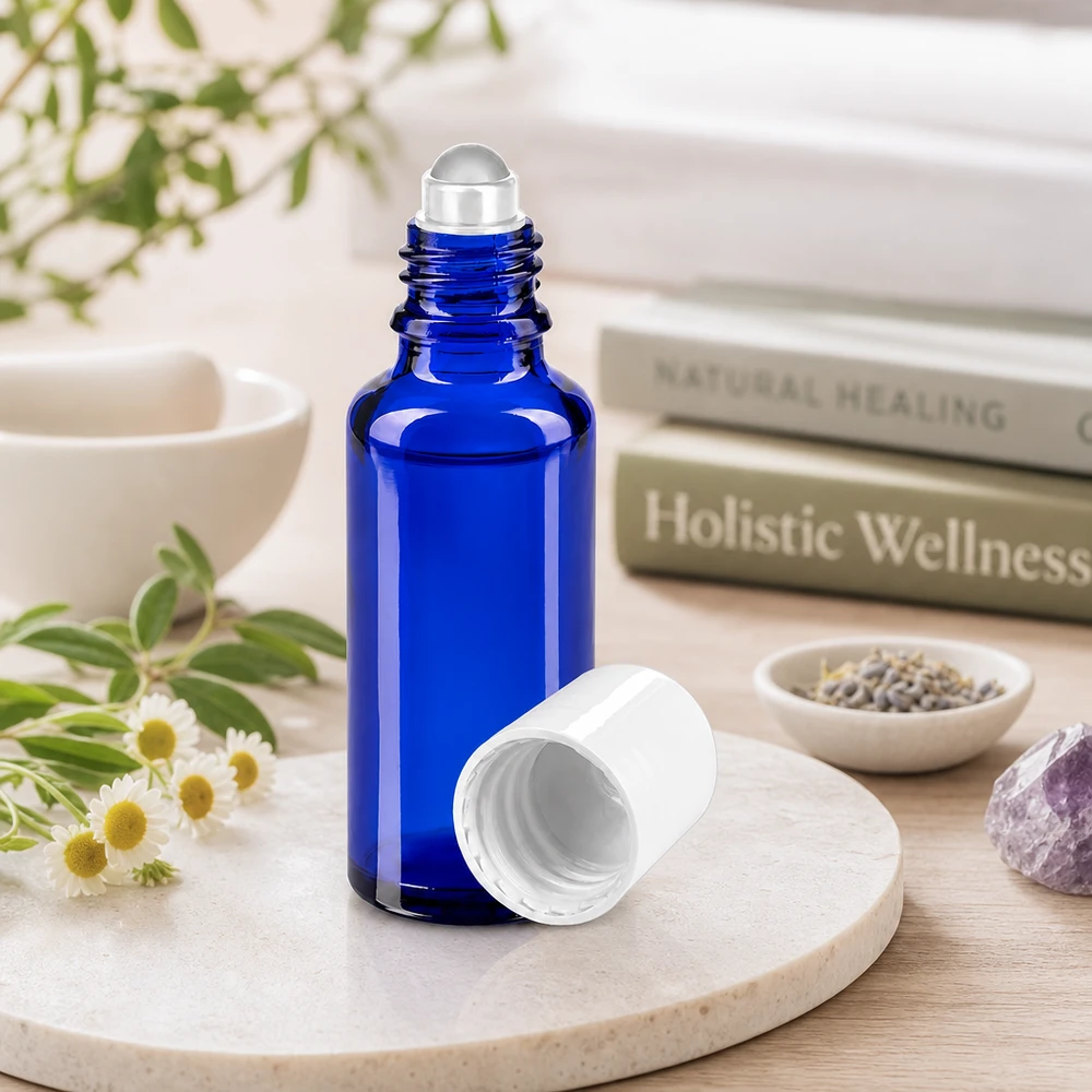 Botella de farmacia azul 30ml tapón roll-on blanco Frasco cilíndrico de 30 ml con aplicador de bola, de color azul cobalto y tapón blanco, junto a hierbas medicinales y una amatista