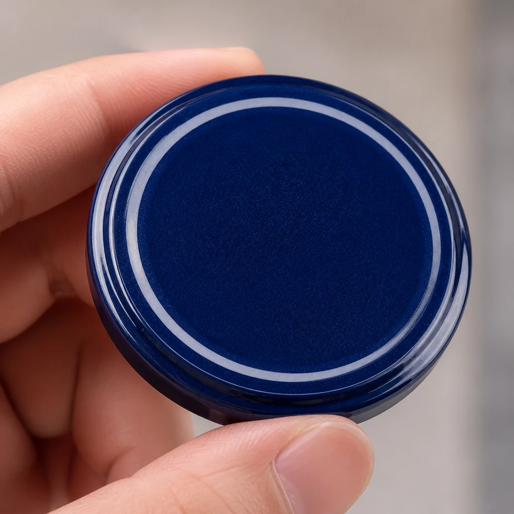 Primer plano de una tapa azul TO82 de 82 mm de BasicSeal, con la parte superior de plástico brillante UNiTWIST