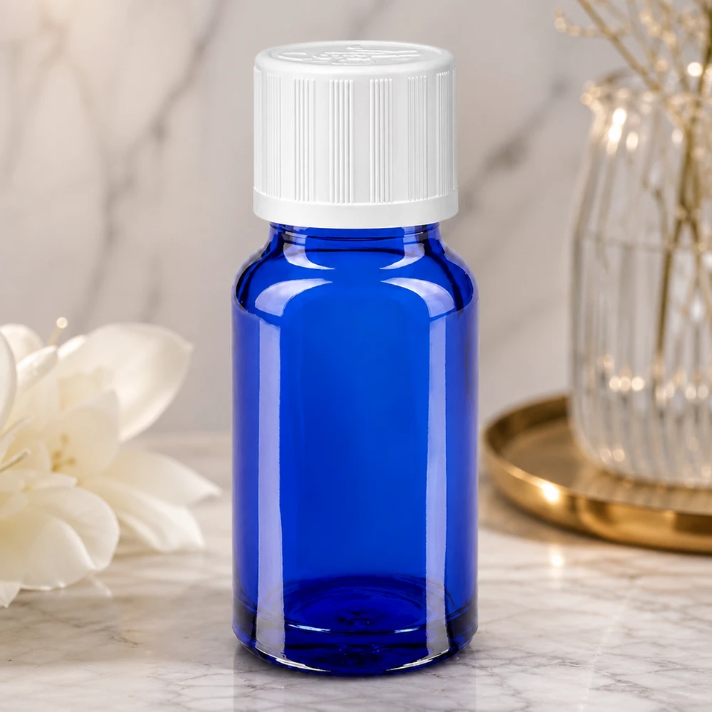 Frasco de farmacia azul cobalto de 10 ml con tapón de seguridad para niños blanco sobre superficie de mármol
