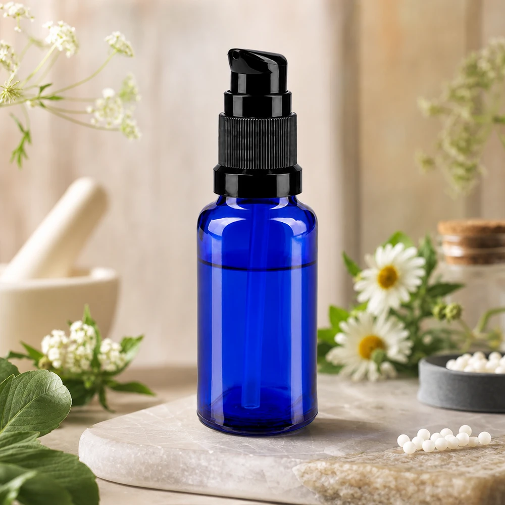 Frasco con dosificador de 20 ml, de vidrio protector azul cobalto, con cabezal de dosificación negro sobre piedra natural