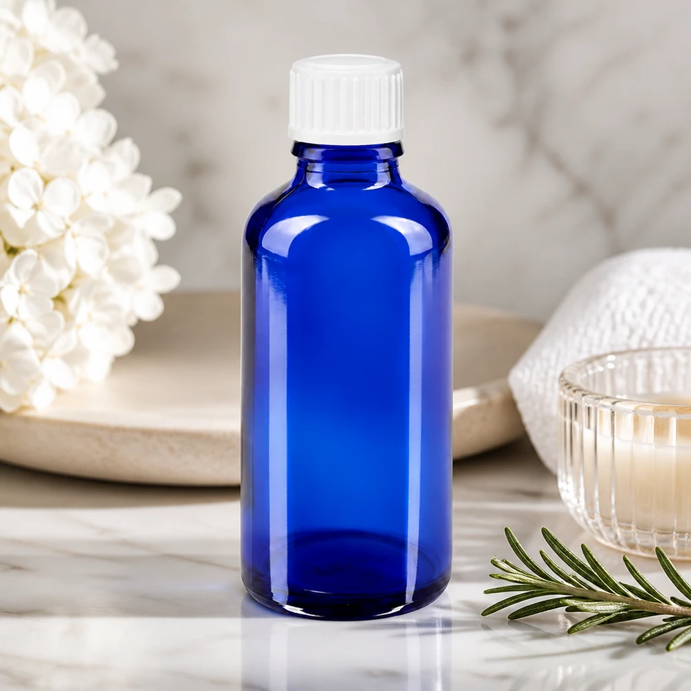 Botella de farmacia azul 50ml tapón de rosca blanco glóbulos estándar Frasco de cristal azul de farmacia de 50 ml con tapón blanco a prueba de niños sobre fondo de mármol