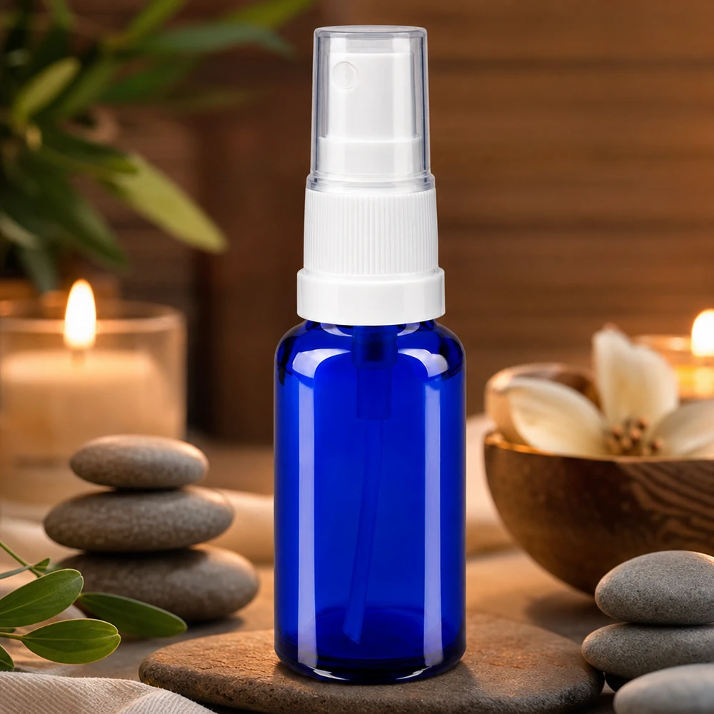 Frasco de cristal de farmacia azul de 20 ml con pulverizador blanco, en un ambiente de spa y bienestar con velas