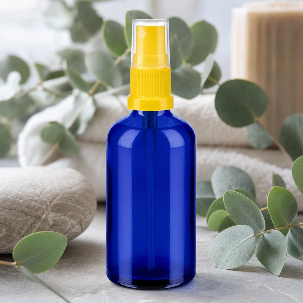 Elegante frasco pulverizador de 100 ml en azul cobalto con diseño ergonómico en amarillo para cosmética natural