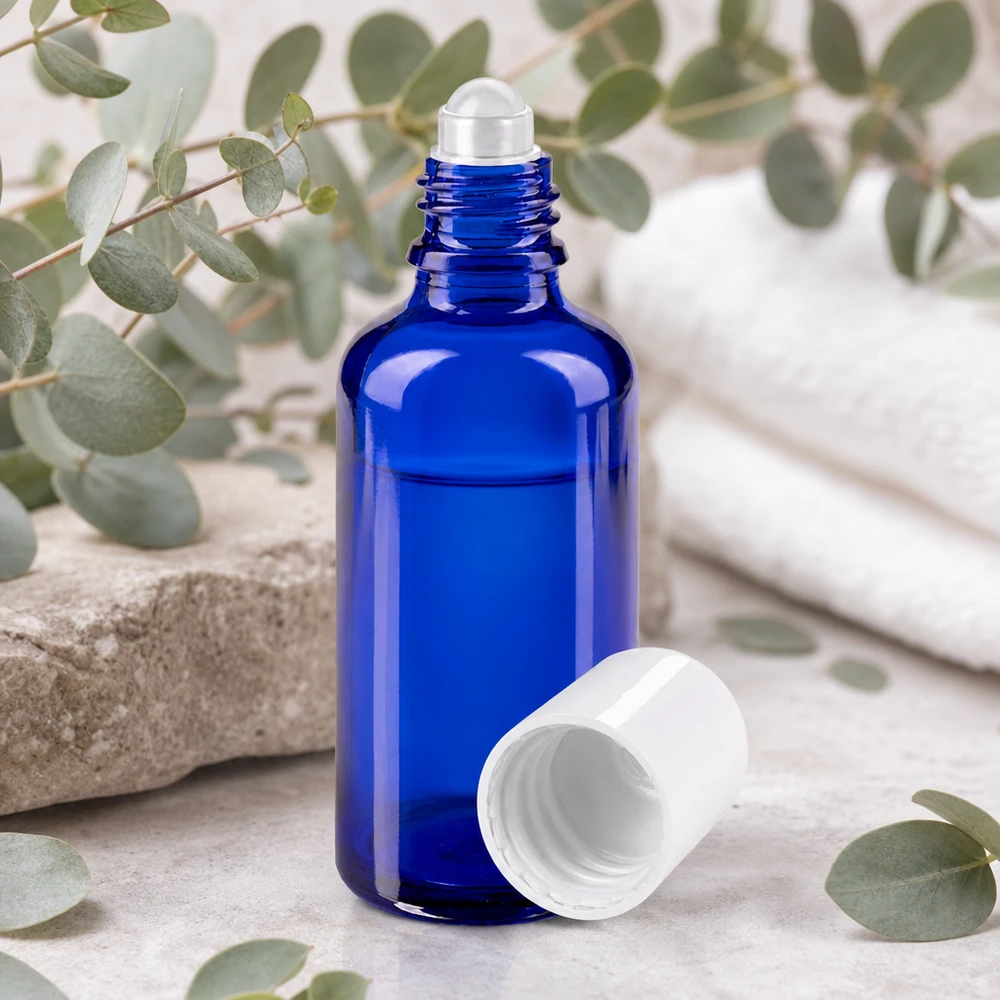 Frasco de farmacia azul de cristal con aplicador de bola de acero inoxidable y tapa blanca abierta, de 50 ml