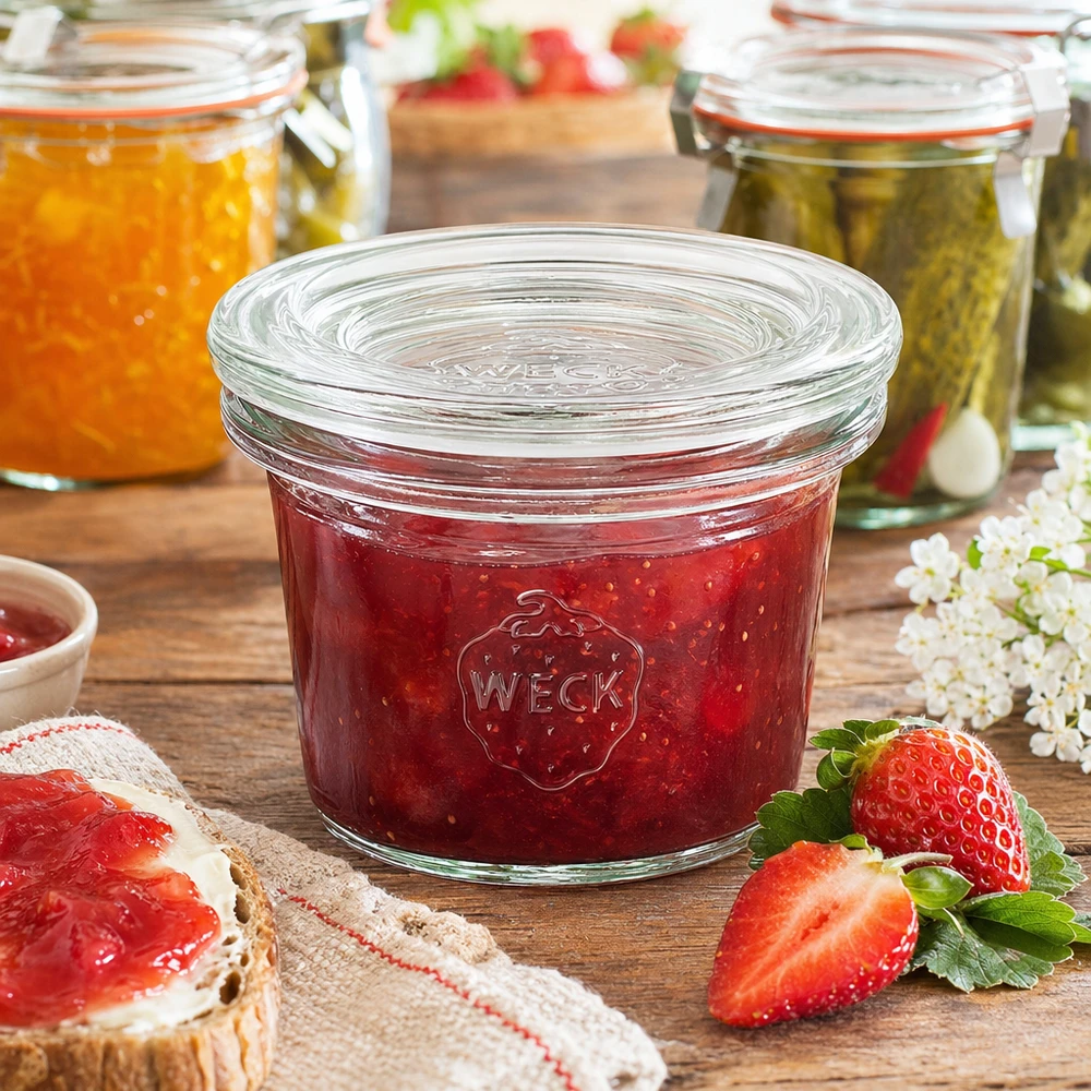 Tarro WECK 35ml RR40 lleno de mermelada de fresa roja junto a fresas frescas y pan de mermelada