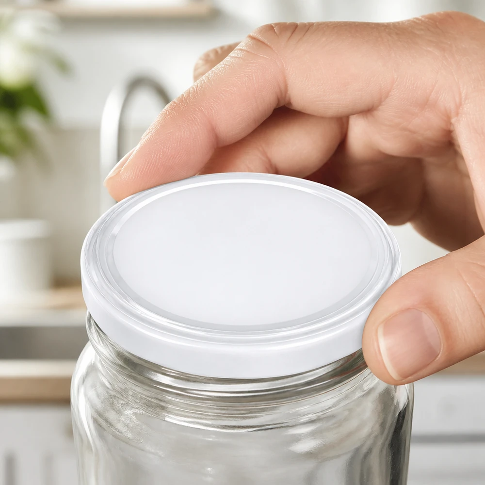 La tapa BasicSeal TO63 de 63 mm, de color blanco, se coloca sobre un tarro de conservas vacío UNiTWIST