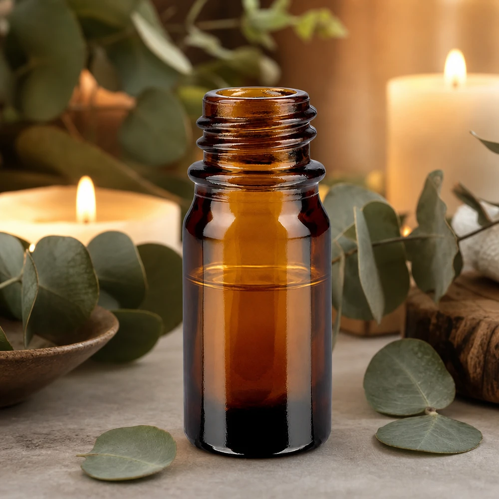 Frasco de farmacia ApoGlas marrón de 5 ml con hojas de eucalipto y velas para la aplicación de aromaterapia relajante