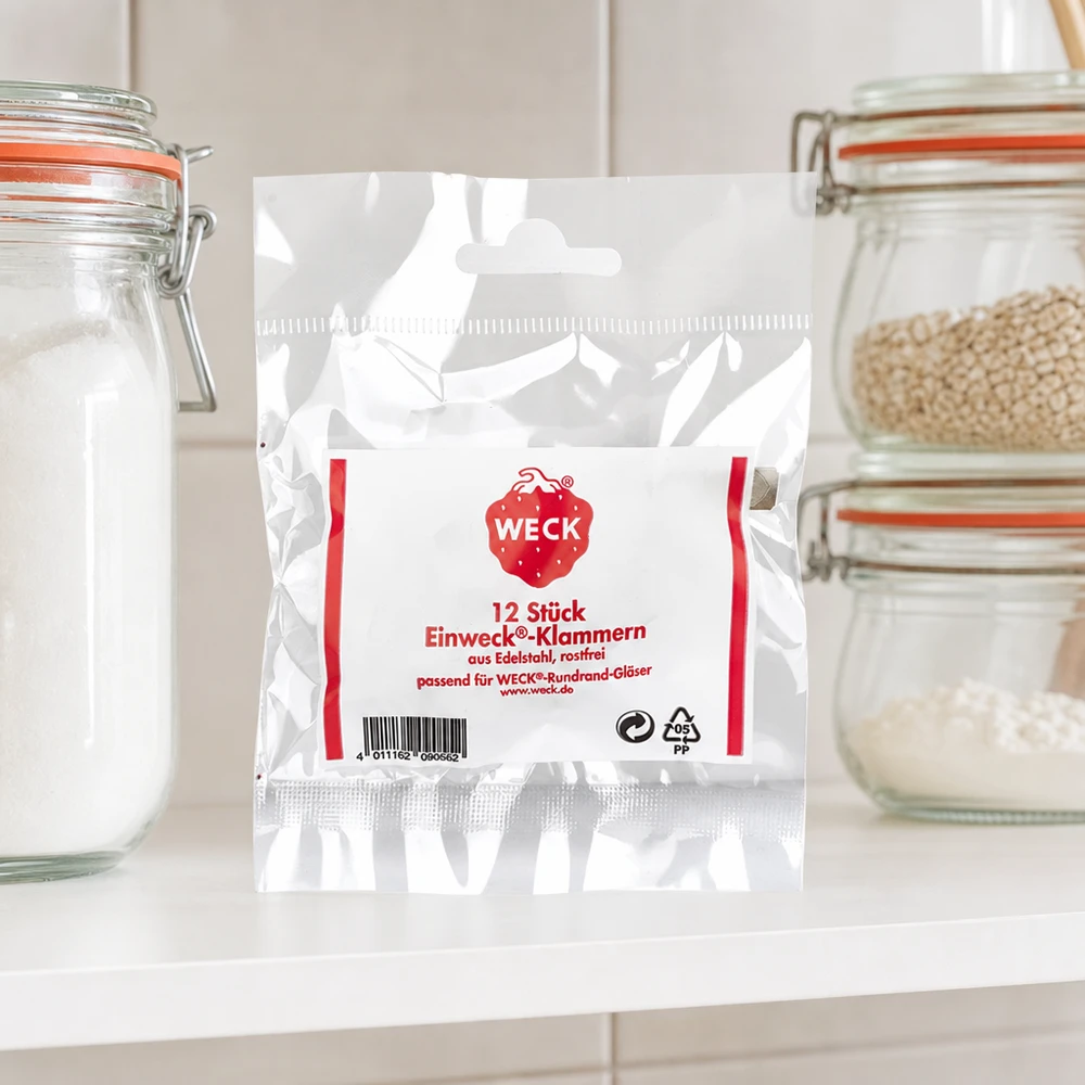 WECK sujeta envases de productos en cocina entre tarros de almacenaje con harina de cereales sobre encimera blanca ambiente cocina
