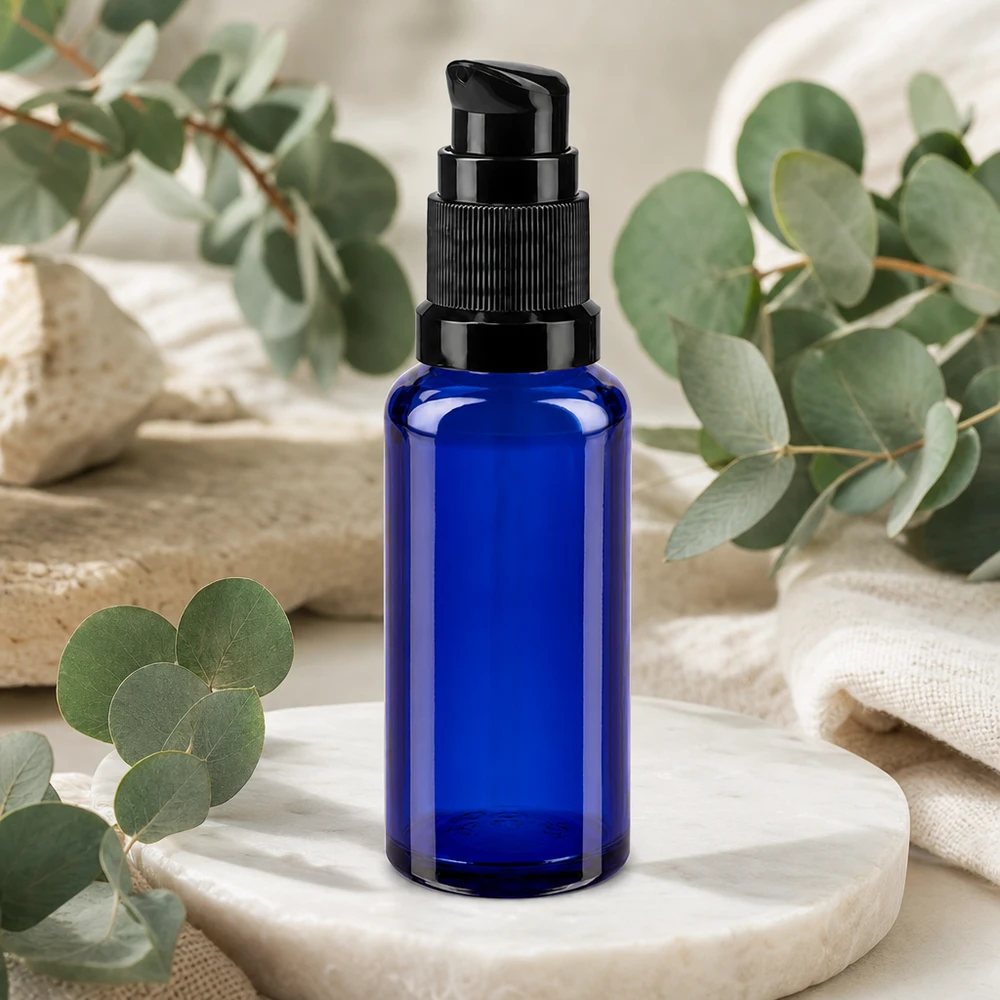 Botella de farmacia azul 30ml tapón pulverizador negro estándar Frasco dosificador azul de 30 ml de cristal de farmacia con cabezal dosificador negro sobre una base de mármol