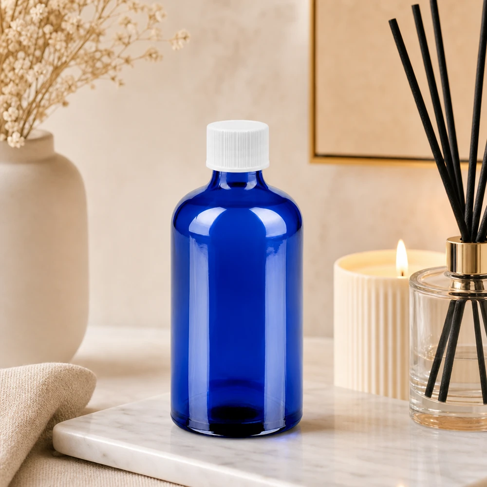 Botella de vidrio compacta de 100 ml en azul brillante con tapón blanco para ahorrar espacio de almacenamiento
