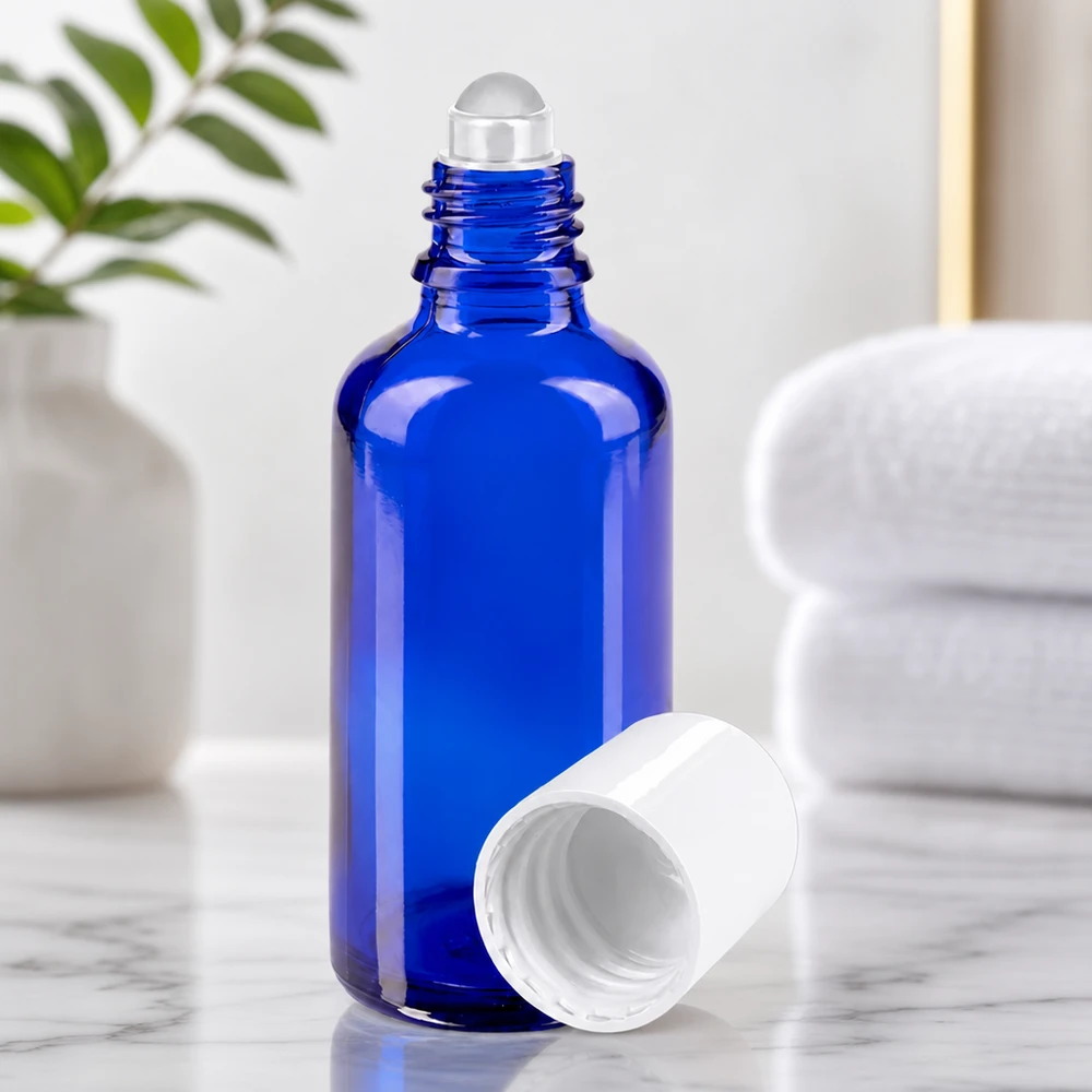Frasco de farmacia cilíndrico de cristal de 50 ml, de color azul, con una bola rodante acoplada y una tapa blanca abierta