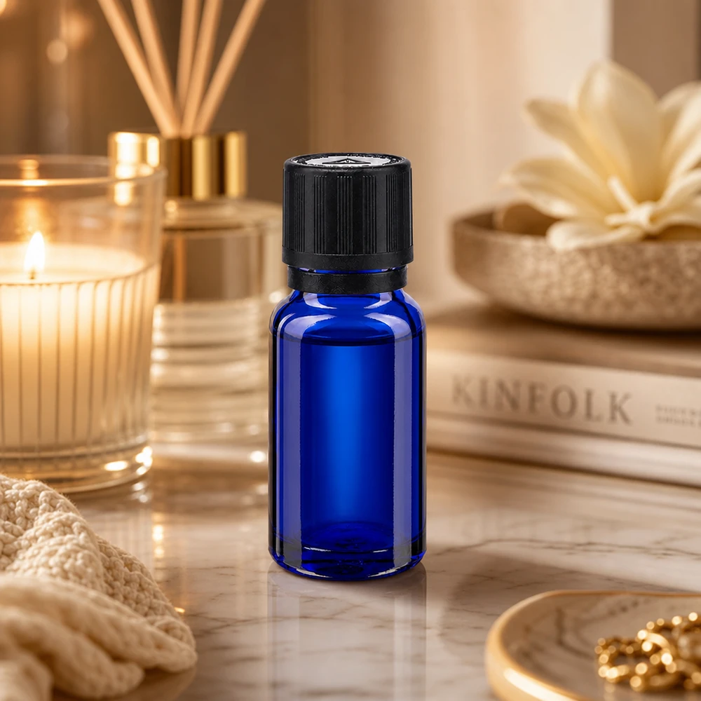 Pequeño frasco de cristal azul de 10 ml con tapón de seguridad para niños de color negro sobre una elegante base de mármol