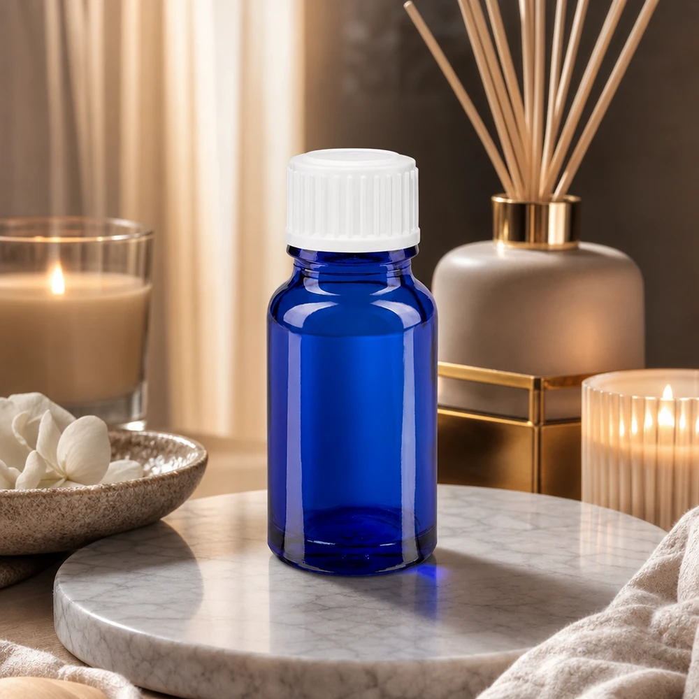 Botella de farmacia azul 10ml tapón rosca blanco estándar Frasco de cristal azul de 10 ml con tapón blanco sobre una bandeja de mármol, rodeado de velas y ambientador