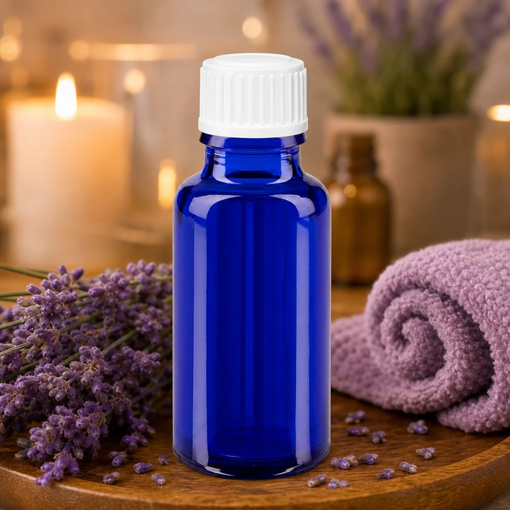Frasco de cristal azul de 20 ml con tapón blanco, rodeado de flores de lavanda sobre una bandeja de madera