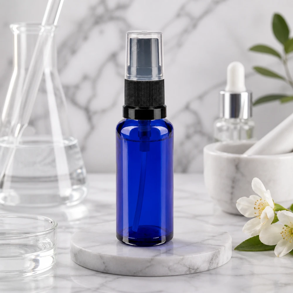 Pequeño frasco pulverizador de 30 ml, de cristal de farmacia azul cobalto, con pulverizador negro y base de mármol